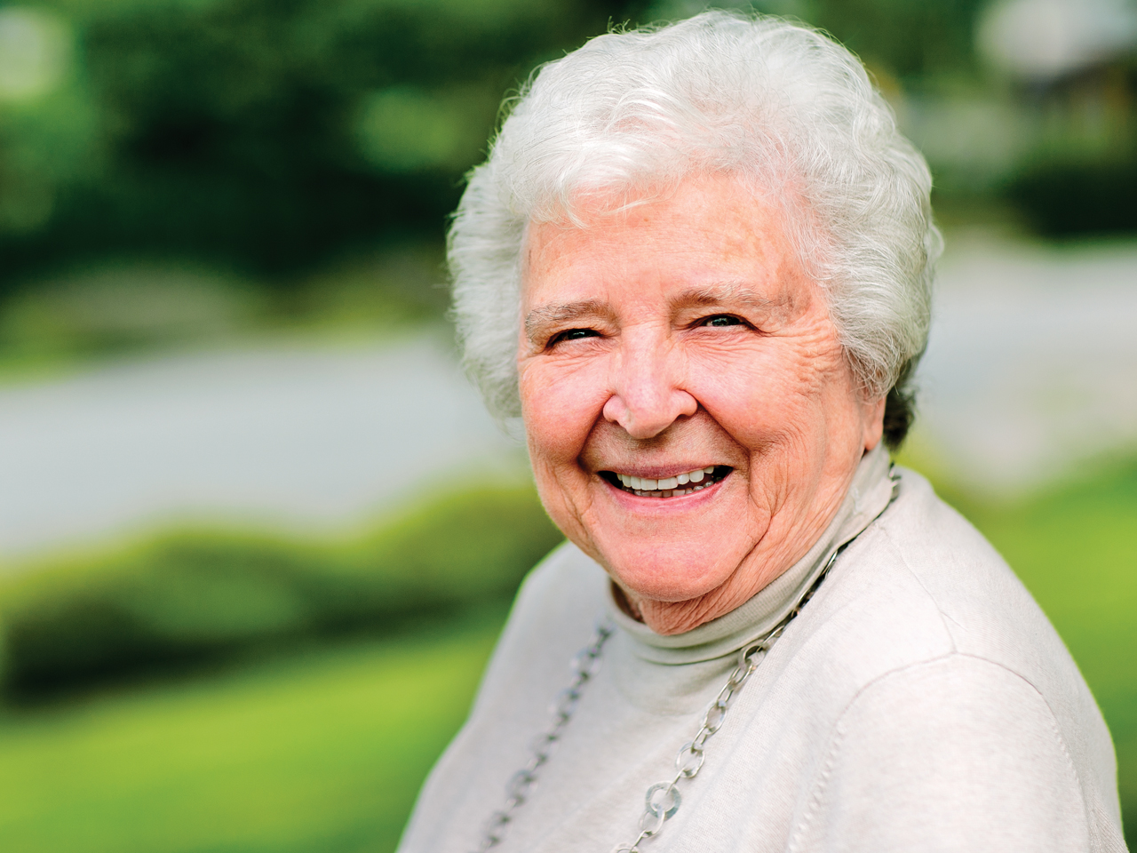 A pictore of Ann Dyke, an elderly woman with white hair, smiling